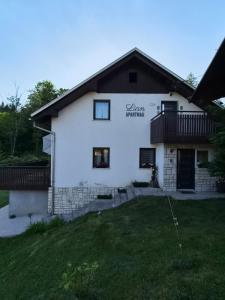 a white house with a yard in front of it at Apartments Lian in Bled