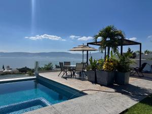 a swimming pool with a table and chairs and an umbrella at Vistas del Angel in San Juan Cosalá