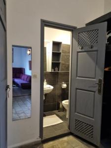 a bathroom with a door leading to a toilet and a sink at Riad7 in Azemmour +78 photos