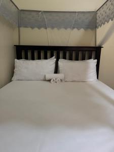 a bed with a pair of towels on top of it at Ciara's Home Entebbe in Entebbe