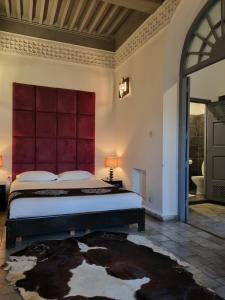 a bedroom with a large bed with a red headboard at Riad7 in Azemmour
