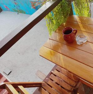 Eine Tasse Kaffee steht auf einem Holztisch in der Unterkunft Cabañas Alebrije in Celestún