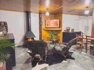 a living room with a fireplace and a table and chairs at Cabana com Hidro, Lareira e Piscina Privativa in Chapecó