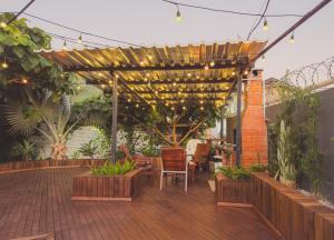 a patio with a table and chairs under a pergola at Cabana com Hidro, Lareira e Piscina Privativa in Chapecó