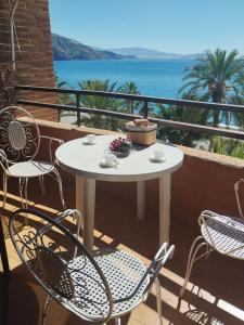 a table and chairs on a balcony with a view of the ocean at Playa Velilla in Granada