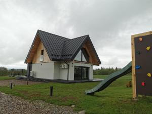 a house with a slide and a playground at Kącik Na Dolinie in Groń