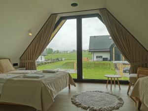 a bedroom with a bed and a large window at Kącik Na Dolinie in Groń
