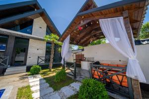 an outdoor patio with a table and umbrellas at Qafqaz Cabana Chalet in Gabala