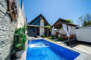 a swimming pool in front of a house at Qafqaz Cabana Chalet in Gabala
