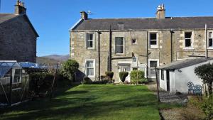 an old house with a yard in front of it at Ardyne House in Port Bannatyne