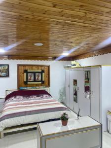 a bedroom with a bed and a wooden ceiling at Bab al-qalaa farm & chalets مزرعة وشاليهات باب القلعه in Ajloun +34 photos