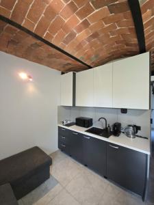 a kitchen with white cabinets and a brick wall at Dom w Młodzianowie in Milicz