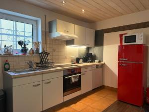 a kitchen with a red refrigerator and a sink at Ferienwohnung AARONA in Memmelsdorf