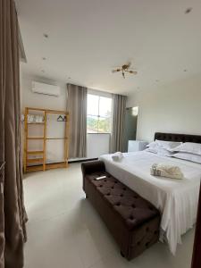 a bedroom with a large bed and a window at Pousada & Restaurante Almescla in Santa Cruz Cabrália
