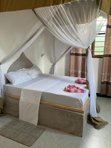 a bedroom with a bed with a canopy at Zanzi coconut house in Jambiani