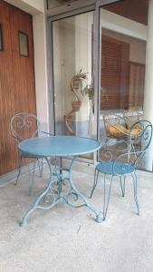 a blue table and two chairs on a patio at Gîte familial 3 chambres- La Flèche - Le Lude in Genneteil