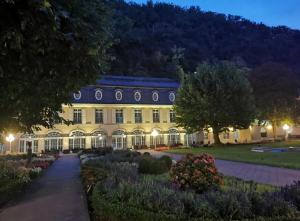 a large yellow building with a garden at night at Haus Sonnenschein in Bad Bertrich