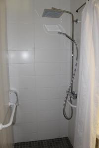 a bathroom with a shower with a shower curtain at Libre Hôtel in La Vespière +14 photos
