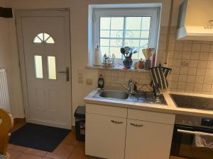 a kitchen with a sink and a window and a door at Ferienwohnung AARONA in Memmelsdorf +4 photos