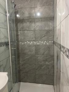 a shower with a glass door in a bathroom at J S mentions in West Thurrock