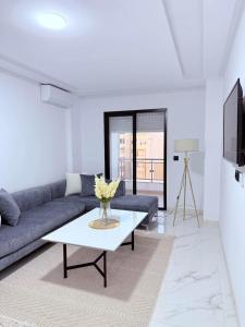 a living room with a couch and a table at Résidence jawhret el kram in El Aouina Station