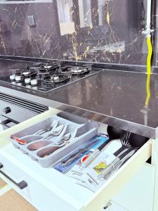 an open drawer in a kitchen with a stove at Résidence jawhret el kram in El Aouina Station +8 photos