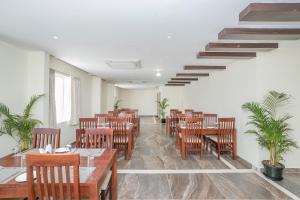 a restaurant with wooden tables and chairs and a staircase at Super Hotel O Ivy Dew Drops in Bangalore