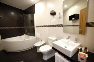 een badkamer met een bad, een toilet en een wastafel bij Hotel Rural Quinta da Conchada in Aguieira