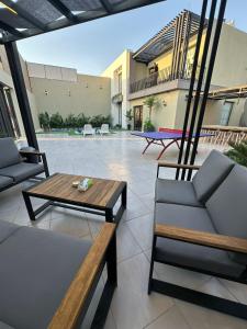 a patio with a table and chairs and a pool at TRIO Chalet 1 in Sowayma