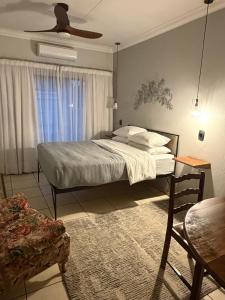 a bedroom with a bed and a ceiling fan at Douglas Villas in Tzaneen