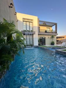 a swimming pool in front of a house at TRIO Chalet 1 in Sowayma