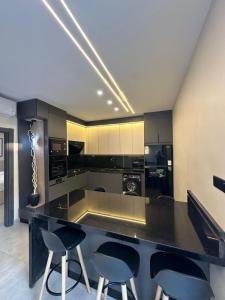a kitchen with a large black counter and chairs at TRIO Chalet 1 in Sowayma