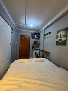 a bedroom with a large bed with a tv on the wall at Amani Nest in Arcadia +1 photo