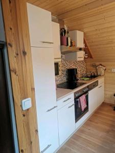 a kitchen with white appliances in a wooden cabin at Haus Sonnenschein in Bad Bertrich