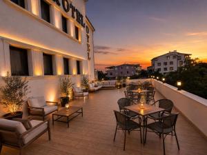 a rooftop patio with tables and chairs on a building at çayır butik otel in Marmaraereglisi