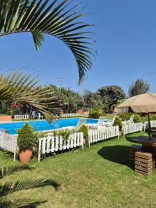 a row of white fences in front of a pool at Bungalows Payancas de Tato in Barranca