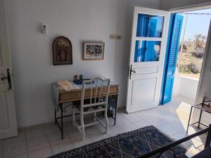 a room with a desk with a chair and a door at Dar Cally Maison d Artiste in Midoun