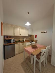 a kitchen with a table and a kitchen with white cabinets at Kipos Apartments in Kassiopi