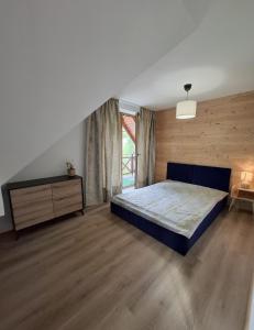 a bedroom with a bed and a wooden floor at Zacisze Wilcza in Zarzecze