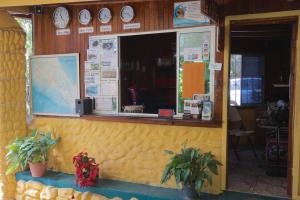 un restaurant avec un comptoir aux horloges murales dans l'établissement Hotel Aurora, à Montezuma