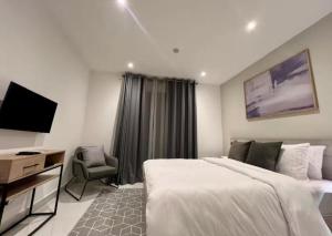 a hotel room with a bed and a television at Green Palm Resort Lekki in Ikuata