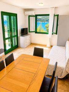 a dining room with a table and a bed at Povlja Bungalows in Povlja