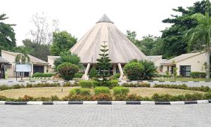 a building with a pyramid roof with a garden at Green Palm Resort Lekki in Ikuata +10 photos