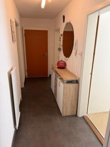 a hallway of a bathroom with a sink and a mirror at Cosy Place in Monthey