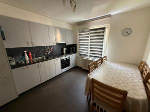 a kitchen with white cabinets and a table with chairs at Cosy Place in Monthey