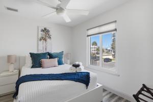 a bedroom with a bed with blue pillows and a window at Be A Nomad - 3 Bedroom Apartment 1 Min to Jacksonville Beach - Sleeps 6 in Jacksonville Beach