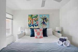 a white bedroom with a bed with two pillows at Be A Nomad - 3 Bedroom Apartment 1 Min to Jacksonville Beach - Sleeps 6 in Jacksonville Beach