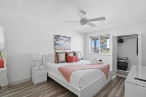 a white bedroom with a bed and a ceiling fan at Be A Nomad - 3 Bedroom Apartment 1 Min to Jacksonville Beach - Sleeps 6 in Jacksonville Beach
