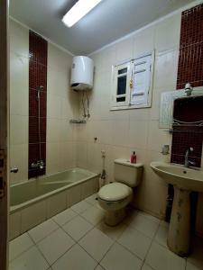 a bathroom with a tub and a toilet and a sink at El Agamy Hotel Apartment in Luxor +60 photos