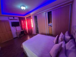 a bedroom with a large bed with purple lights at Villa ETAHIRI in Marrakesh +2 photos